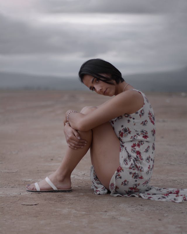 girl who makes a choice to sit on sandy beach