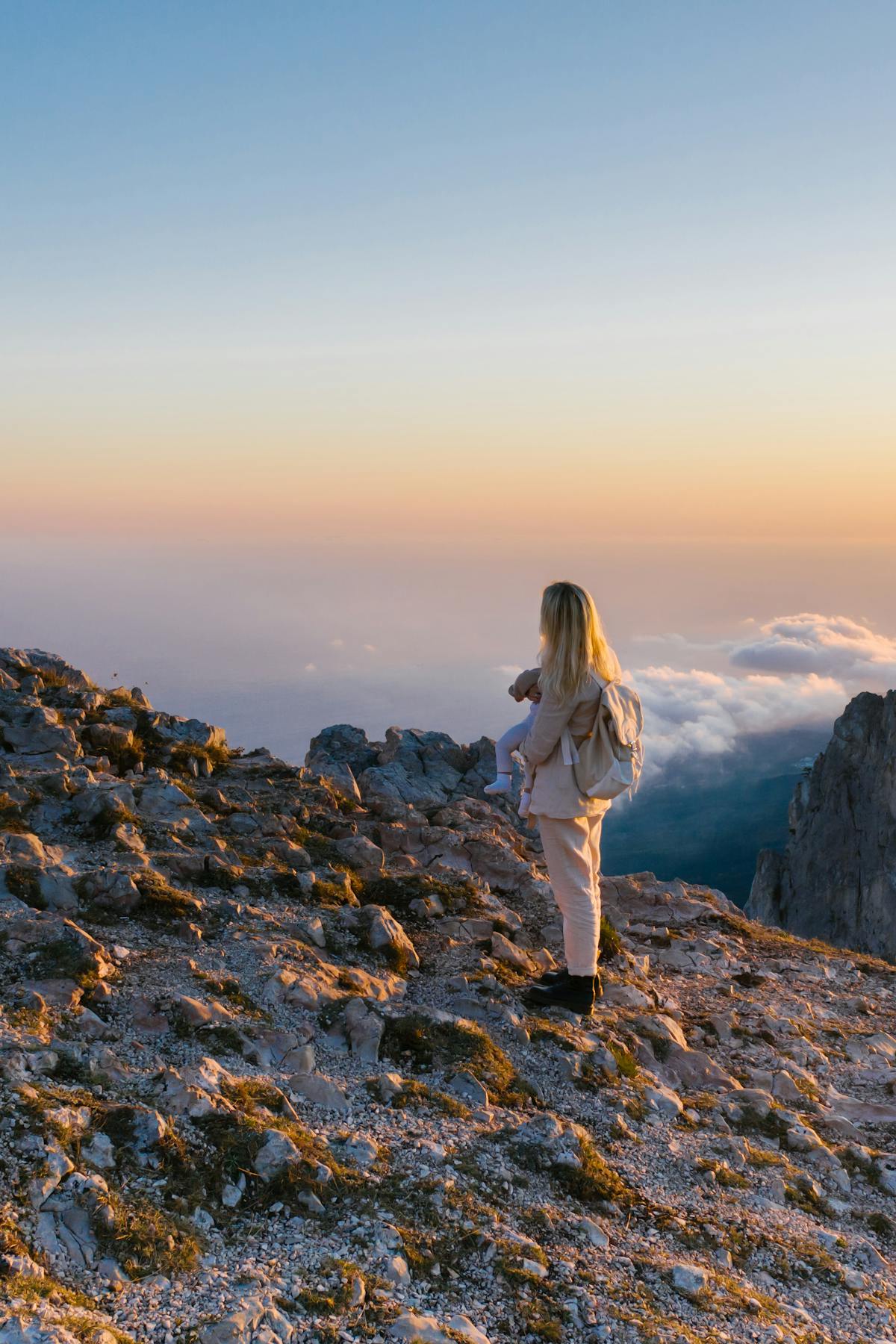 woman looking out from peak of mountain while feeling behind in life.