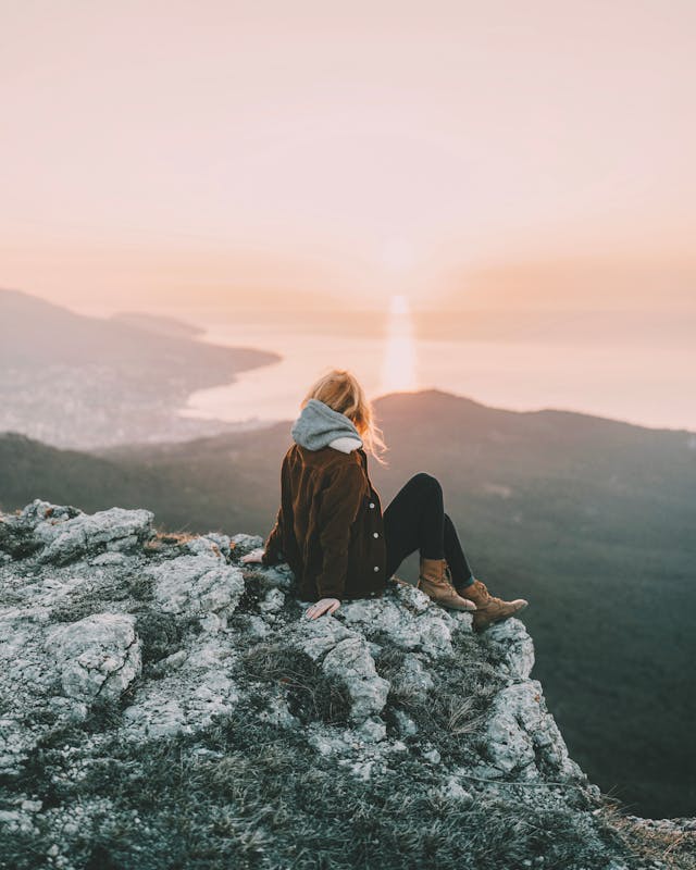 Woman thinking about habitual balance as she stares on the sunset.