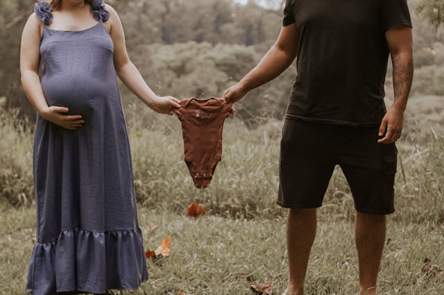 A couple holding a onsie