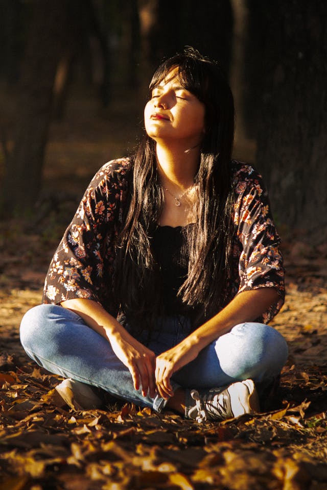 girl sitting in the sunlight with light reflecting on her face