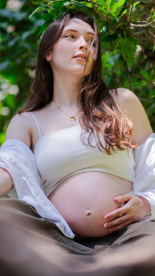 Young pregnant woman with her hand on her exposed belly