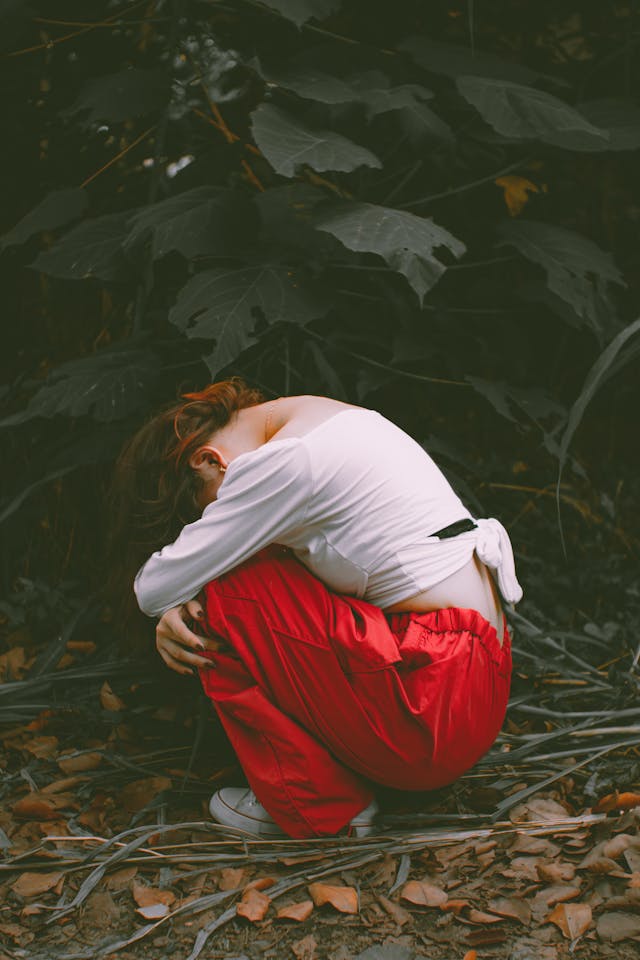 girl in red pants cradled up into fetal position needing new boundaries in life