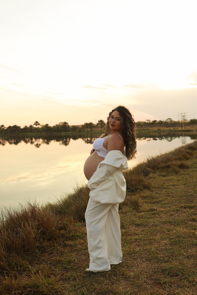 Pregnant woman in bra by lakeside