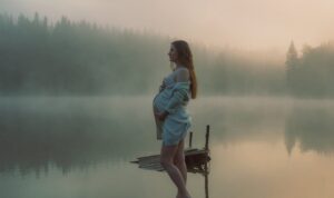 Pregnant lady standing in front of water